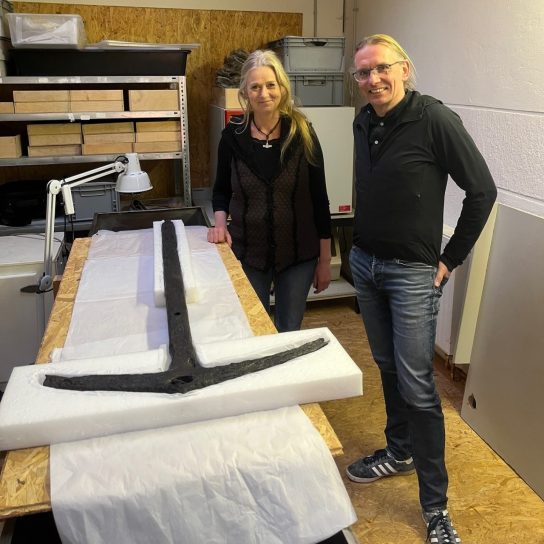 Helena Kretzschmar und Dr. Jan F. Kegler zeigen den Anker (Foto: Ostfriesische Landschaft).